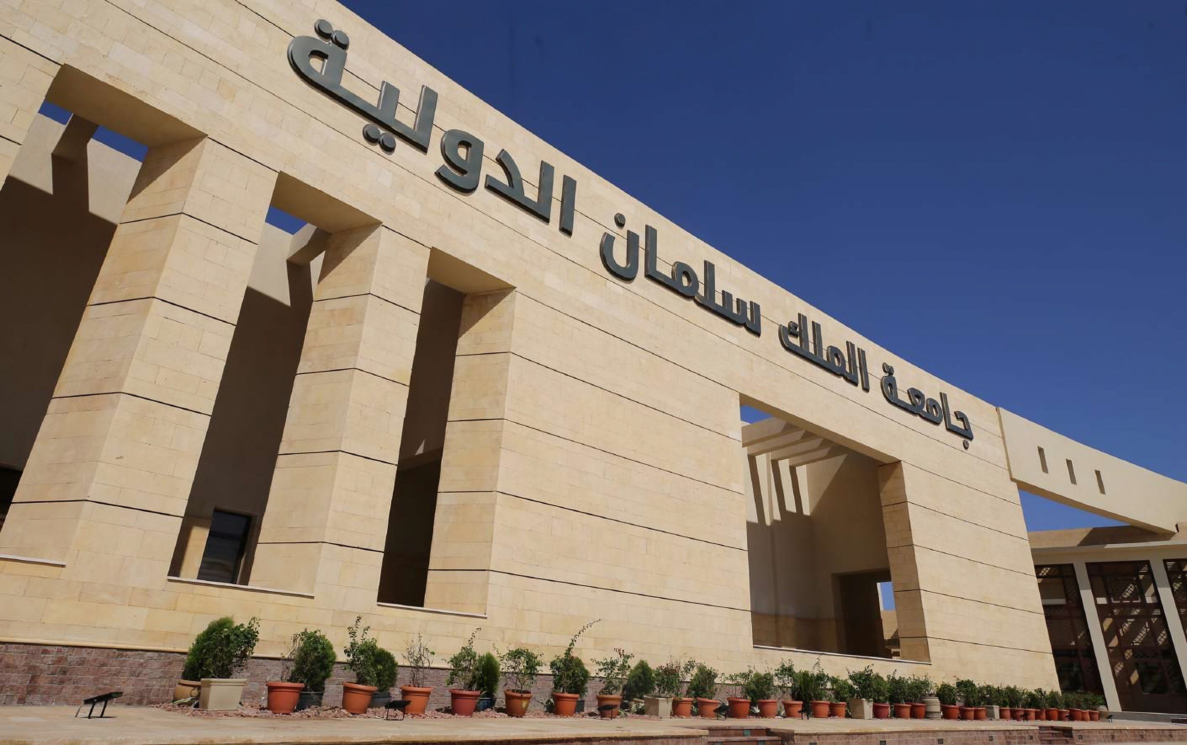 A MAFEC engineer in a site vest points at the entrance of King Salman International University. (2)